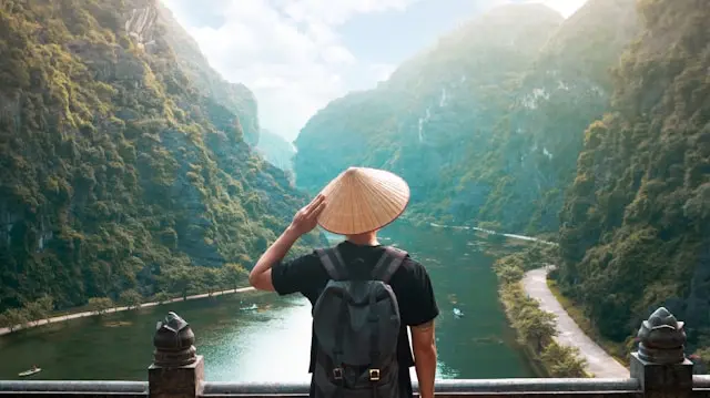 Backpacker insurance Vietnam - backpacker with travel bag on Vietnamese mountain road with rice terraces